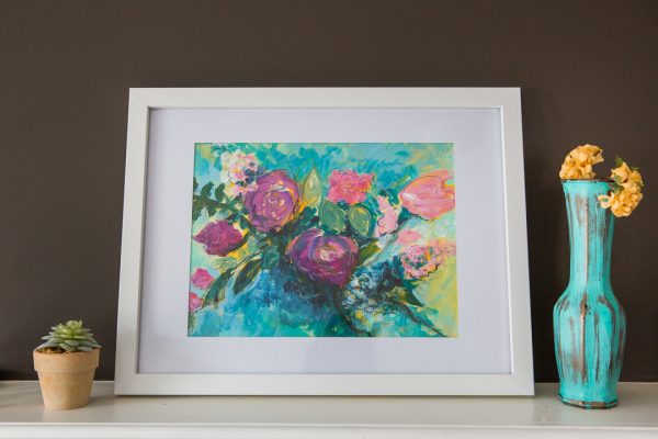 A white framed acrylic floral painting of a pink rose bouquet against an abstract teal and yellow background.